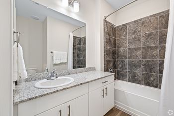A bathroom with a sink and a shower and a mirror 
