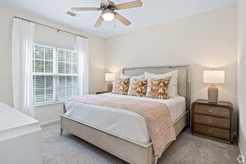 A bedroom with a bed and a ceiling fan 