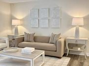 Gautier apartment for rent - A living room with a beige couch, two lamps, and a coffee table at The Pointe Apartment Homes, Gautier, MS