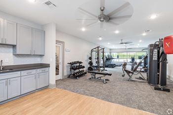 A home gym with exercise equipment and a ceiling fan