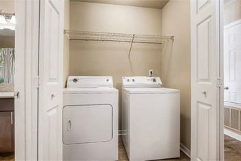 A small laundry room with a washer and dryer