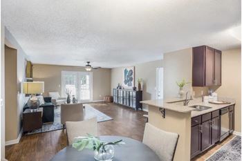 A modern kitchen with a dining table and chairs and hardwood floors