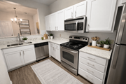 Tyler apartment for rent - A modern kitchen with white cabinets and stainless steel appliances.