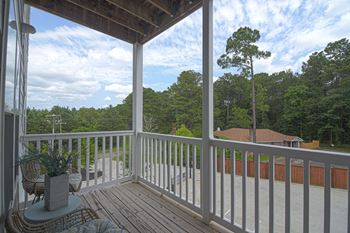 A porch with a view of the trees and a blue sky