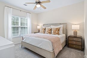Hattiesburg apartment for rent - a bedroom with a bed and a ceiling fan at The Met Apartment Homes, Mississippi 39402