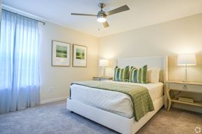 Brandon apartment for rent - a bedroom with a bed and a ceiling fan at The Vineyard at Castlewoods Apartment Homes in Brandon, MS 39047