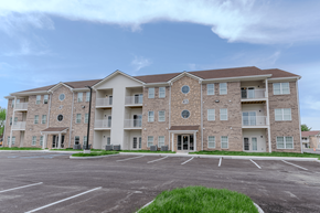 Greenwood apartment for rent - an empty parking lot in front of an apartment building at The Village at Sandstone Apartments, Indiana