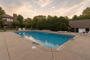 Kalamazoo apartment for rent - A large outdoor swimming pool surrounded by trees and a house.