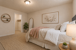 Louisville apartment for rent - A bedroom with a bed, lamp, and a plant.