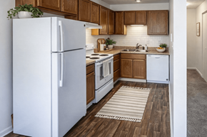 New Albany apartment for rent - A white refrigerator stands in a kitchen with wooden cabinets and a white dishwasher.