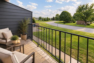 Louisville apartment for rent - A balcony with a table and chairs overlooking a green lawn.