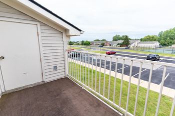 The view from the balcony of a house overlooking a parking lot