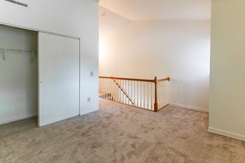 An empty room with a staircase and a closet