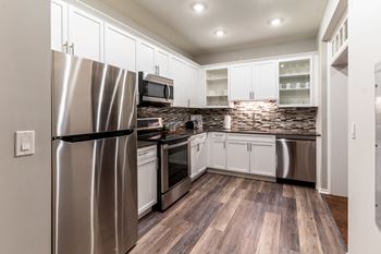 A kitchen with stainless steel appliances and white cabinets