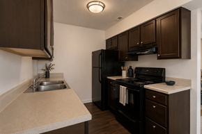 Westfield townhouse for rent - A kitchen with brown cabinets and black appliances.