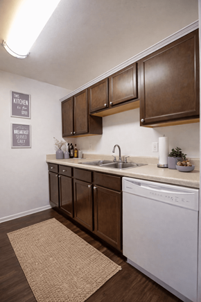 Indianapolis townhouse for rent - A kitchen with brown cabinets and a white dishwasher.