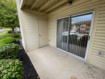 A patio in front of a house with a door