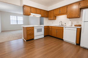 Greenwood apartment for rent - A kitchen with wooden cabinets and white appliances.