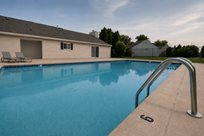 Indianapolis townhouse for rent - A swimming pool with a ladder and a house in the background.