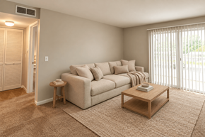 Kokomo apartment for rent - A living room with a couch, a small table, and a window with blinds.