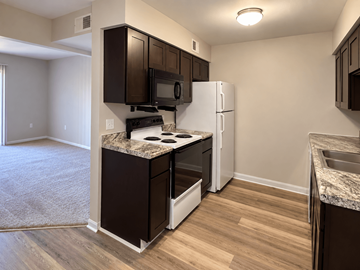 Kokomo apartment for rent - A kitchen with brown cabinets and a white refrigerator.