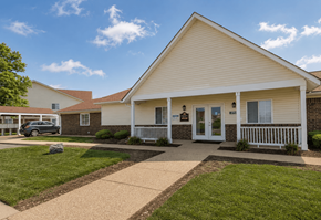 Indianapolis apartment for rent - A small white building with a porch and a car parked in front.