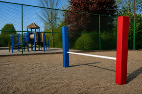 Indianapolis apartment for rent - A playground with a blue and red pole in the foreground and a swing set in the background.