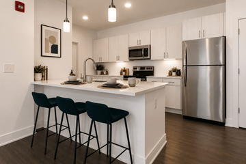 Indianapolis apartment for rent - A modern kitchen with a white countertop and black barstools.