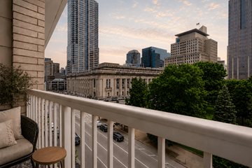 Indianapolis apartment for rent - A balcony with a chair and table overlooking a city street.