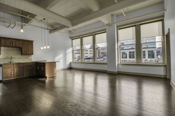 Open loft apartment with exposed ductwork and large windows