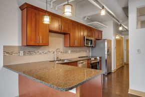 Buffalo apartment for rent - Kitchen with island granite countertops and pendant lighting at 100 South Apartments, New York, 14202