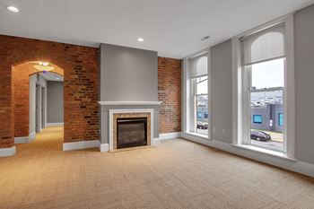 Empty living space with fireplace and large windows