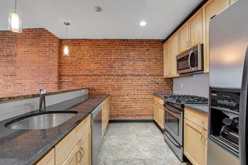 Kitchen with exposed brick walls and stainless appliances
