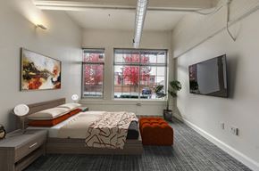 Buffalo apartment for rent - A bedroom with a bed, nightstand, and a painting on the wall.