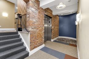 Buffalo apartment for rent - the front door of a building with a brick wall and stairs at The Granite Works Apartments , Buffalo, NY