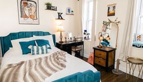 Pittsburgh apartment for rent - a bedroom with a blue and white bed and a wooden dresser with a mirror on it