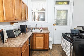 Pittsburgh apartment for rent - A kitchen with wooden cabinets and a black stove top.