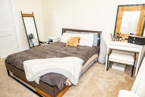 Pittsburgh apartment for rent - A bedroom with a bed, desk, chair, and mirror.