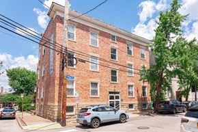 Pittsburgh apartment for rent - A red brick building with a blue sign on the front.