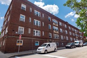 Pittsburgh apartment for rent - A white van is parked on the street in front of a brick building.