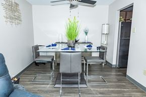 Monroeville apartment for rent - A dining room with a table set for two and a blue couch. at Walnut Crossings, Monroeville, PA, 15146