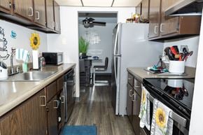 Monroeville apartment for rent - A kitchen with wooden cabinets and a stainless steel refrigerator. at Walnut Crossings, Monroeville, PA, 15146