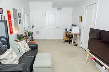 Pittsburgh townhouse for rent - A living room with a black couch and a television.