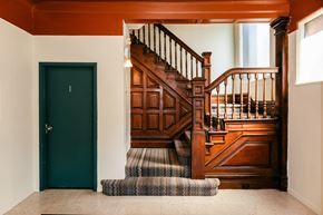 Pittsburgh apartment for rent - A wooden staircase with a green door on the left.