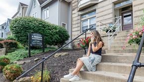 Pittsburgh apartment for rent - a woman sitting on the steps of a building talking on her cell phone