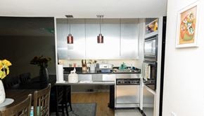 Pittsburgh apartment for rent - a kitchen with white cabinets and a black table with a vase of yellow flowers