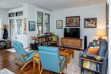 Pittsburgh townhouse for rent - A living room with a blue chair and a black couch.