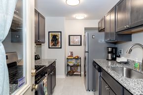 Pittsburgh townhouse for rent - A kitchen with black cabinets and a stainless steel refrigerator.