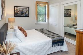 Pittsburgh townhouse for rent - A bedroom with a bed, nightstand, and a mirror.
