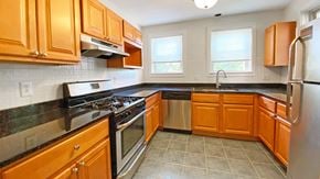 Pittsburgh townhouse for rent - a kitchen with wooden cabinets and stainless steel appliances